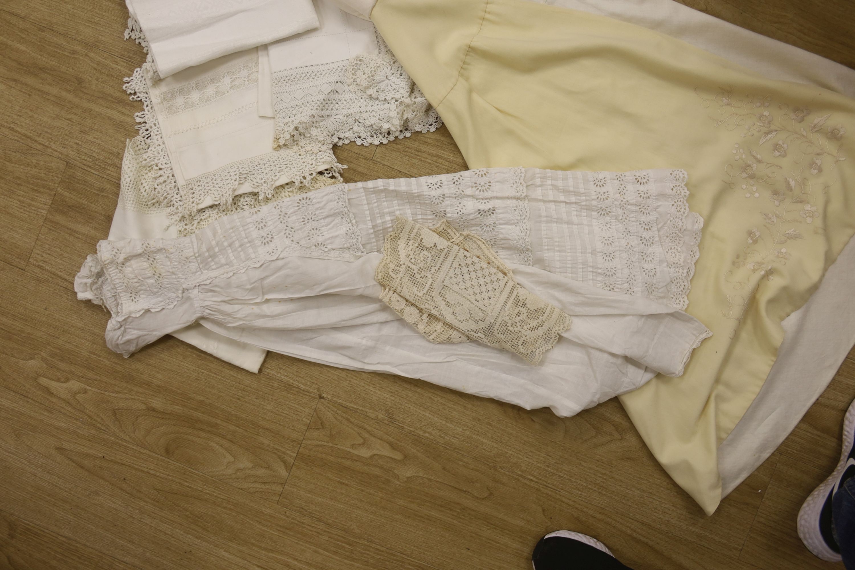 A 19th century embroidery anglais christening gown and nun's veiling cape, together with a small collection of tablecloths, etc